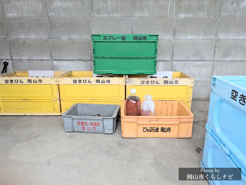 岡山市の資源化物収集所に並ぶコンテナ（乾電池・てんぷら油・空きびん・空き缶・スプレー缶）